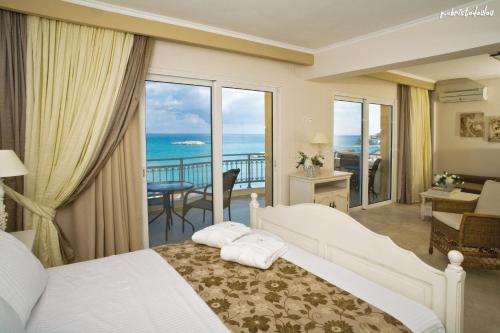 Hotel Astron Princess في كارباثوس: غرفة نوم مع سرير وإطلالة على المحيط