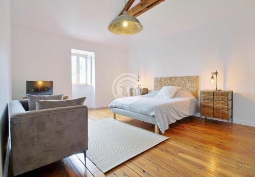 sypialnia z łóżkiem, krzesłem i kanapą w obiekcie villa corina w mieście Tarbes