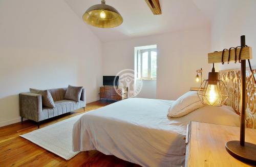 a white bedroom with a bed and a couch at villa corina in Tarbes