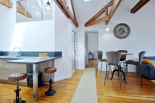 a kitchen and living room with a table and stools at villa corina in Tarbes