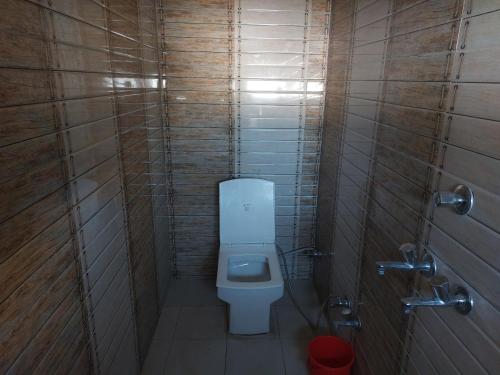 a small bathroom with a toilet in a stall at Hotel Kota kunj Heritage in Pushkar