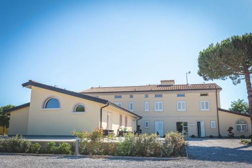 a large house with a tree in front of it at Hotel Residence Vallecorsa in Vada