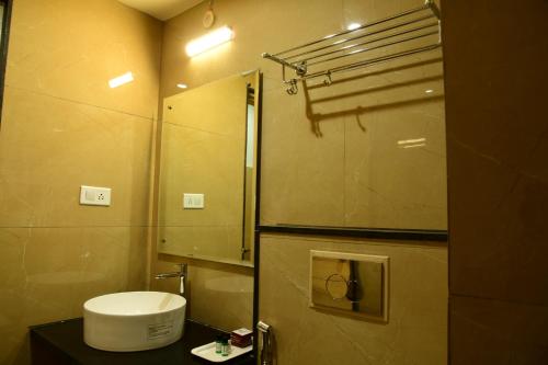 a small bathroom with a sink and a mirror at Hotel U.T.ELITE in Bengaluru