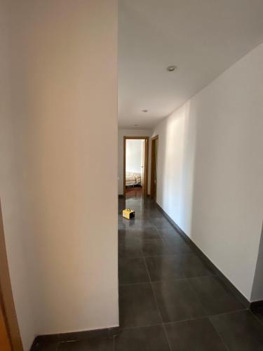 a hallway with white walls and a tile floor at Amplio apartamento en el centro de O Grove in O Grove