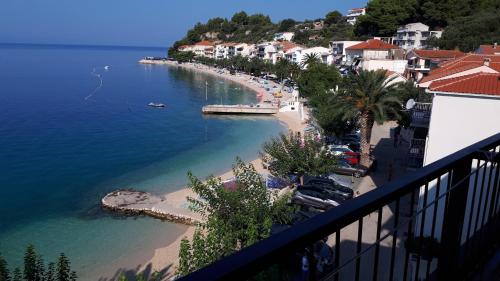 a view of a beach and the ocean from a balcony at Beachfront Comfort Apartments SINAJKO in Podgora