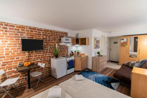 cocina y sala de estar con pared de ladrillo en Apartments24 Vene One, en Rakvere