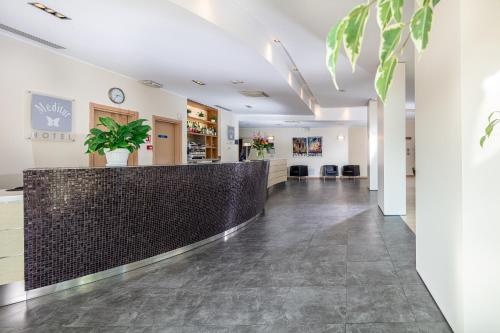 a lobby of a store with a counter and plants at Meditur Hotel Udine Nord in Udine