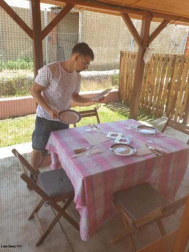 a man standing at a table with a table cloth at Cabaña de madera especial y acogedora in Cardenete