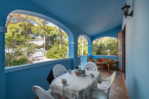 a dining room with blue walls and a table and chairs at CASA AZZURRA in Cala Liberotto