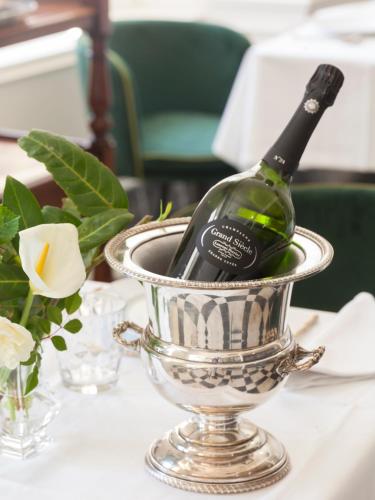 a bottle of wine in a silver bucket on a table at Gran hotel Brillante in San Esteban de Pravia