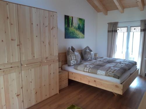 a bedroom with wooden cabinets and a bed in a room at Gästehaus Andreas in Schönsee