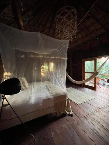 a bed in a room with a net at Casa Blanca in Holbox Island