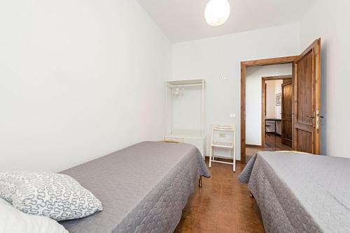 a bedroom with two beds and a hallway at Casa degli Ulivi in San Felice del Benaco