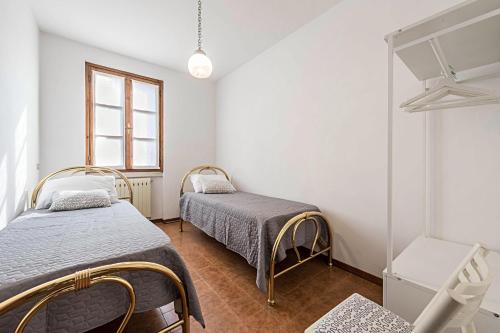 1 Schlafzimmer mit 2 Betten und einem Fenster in der Unterkunft Casa degli Ulivi in San Felice del Benaco