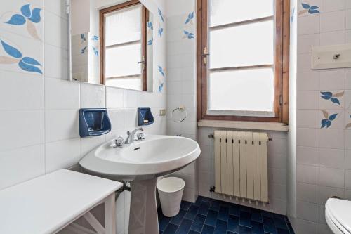 ein Badezimmer mit einem Waschbecken, einem WC und einem Spiegel in der Unterkunft Casa degli Ulivi in San Felice del Benaco