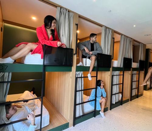 The Boc Hostels - City في بالما دي ميورقة: مجموعة من الناس يجلسون على سرير بطابقين في غرفة