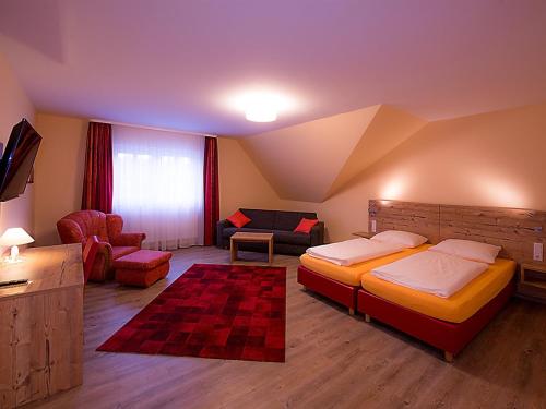 a bedroom with a bed and a couch and a chair at Landgasthof Schwarzes Roß in Ansbach