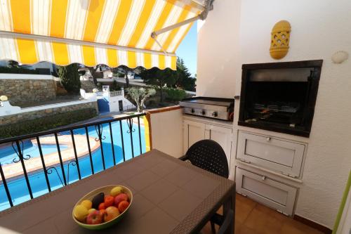 - une cuisine avec une table et un bol de fruits sur un balcon dans l'établissement Jardins II 1-9 Pisos con piscina en Roses, à Roses
