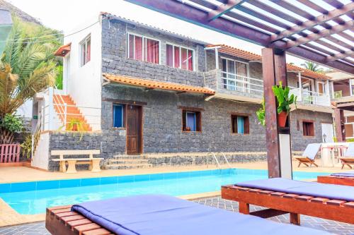 a villa with a swimming pool and a house at Pousada Quinta Ribeirinha in Cidade Velha