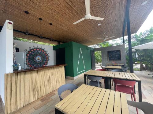 a restaurant with wooden tables and chairs and a counter at Pyramid Tamarindo Luxury Hotel in Tamarindo