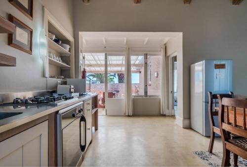 a kitchen with a stove and a refrigerator at Blue Bay Lodge in Saldanha