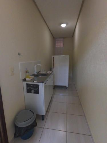 a small bathroom with a sink and a refrigerator at Suíte na Canastra in São Roque de Minas