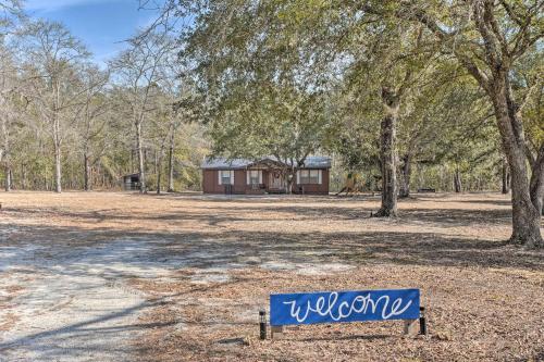 a sign in a field with a house in the background at Charming Retreat on 20 Acres with Private Lake! in Walterboro