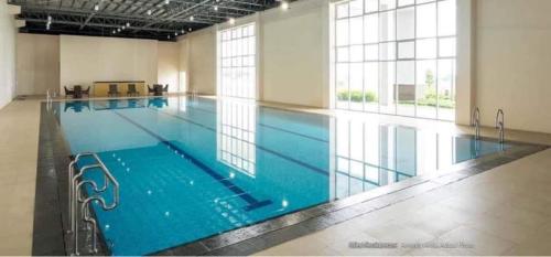 uma grande piscina interior com água azul em Wind Residence T4- I Near TAAL VIEW at sky lounge em Nasugbu