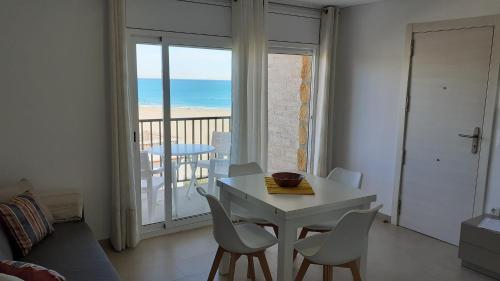 ein Wohnzimmer mit einem Tisch und Stühlen sowie einem Balkon in der Unterkunft Apartamentos Dins Mar Apto. 10 in Torredembarra