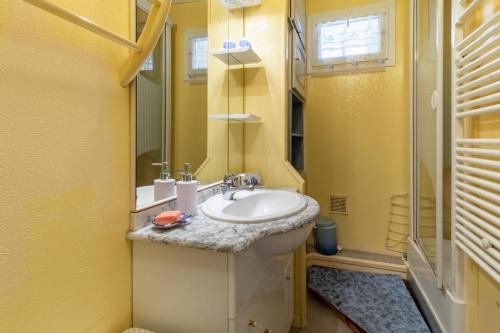 une salle de bain avec un lavabo, des toilettes et un miroir dans l'établissement La Tourette, à Cauterets