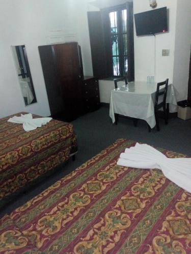 a hotel room with two beds and a table at Hotel Spring in Guatemala