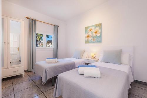 two beds in a room with white walls at Costa den Blau in Porto Cristo