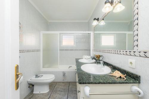 a bathroom with a sink and a toilet and a mirror at Costa den Blau in Porto Cristo