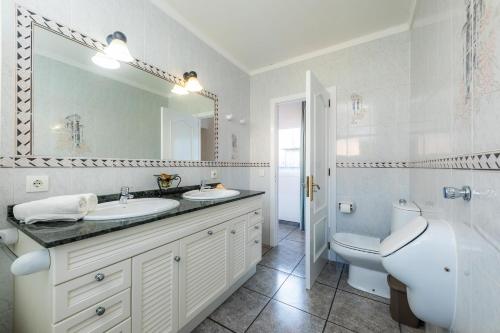 uma casa de banho com um lavatório, um WC e um espelho. em Costa den Blau em Porto Cristo
