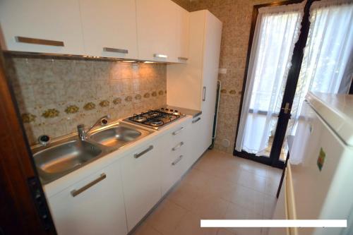 a small kitchen with a sink and a stove at Lignano Pineta Big Villa in Lignano Sabbiadoro