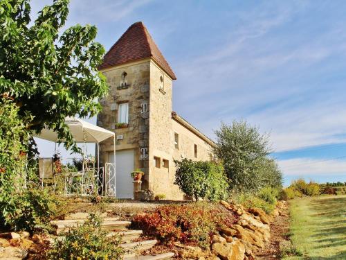 an old stone building with a clock tower at Beautiful holiday home with swimming pool in Monprimblanc