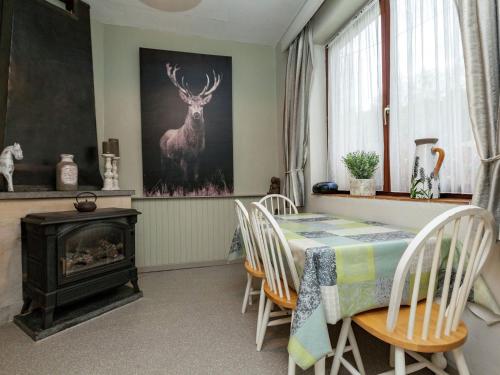 a dining room with a table and a deer painting on the wall at Holiday Home in Malmedy with terrace in Malmedy