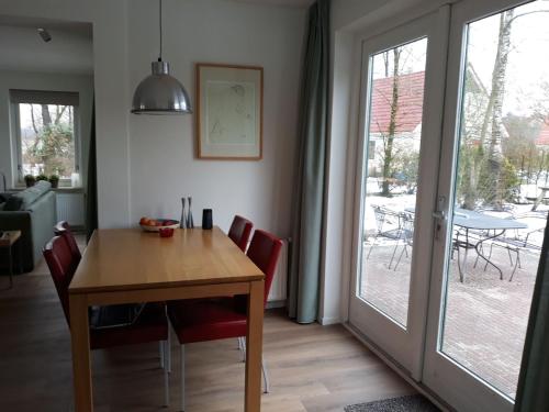 d'une salle à manger avec une table, des chaises et une porte coulissante en verre. dans l'établissement Villa with spacious garden near Heeten, à Heeten