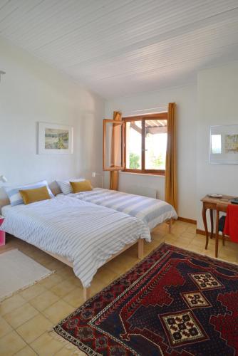 un grand lit dans une chambre avec une fenêtre dans l'établissement Le Mas sous le Vent, à Opio