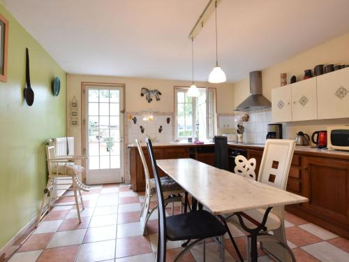 Alluring Cottage in Englancourt with Fenced Garden في Englancourt: مطبخ فيه طاولة وكراسي