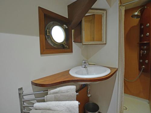 a bathroom with a sink and a mirror and towels at Charming Boat in Villedubert with Terrace in Villedubert