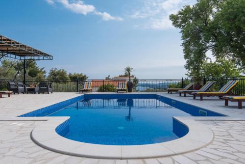 una piscina con acqua blu in un patio di Holiday Villa Andro a Orebić (Sabbioncello)