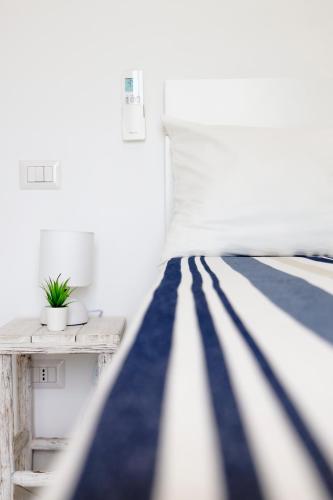 a white bedroom with a bed and a table at Casa Manì in Anacapri