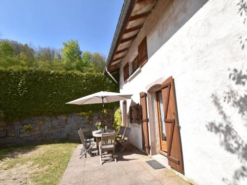 a patio with a table and an umbrella at Holiday home in Saulxures sur Moselotte in Saulxures-sur-Moselotte