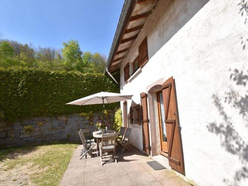 een patio met een tafel en een parasol bij Holiday home in Saulxures sur Moselotte in Saulxures-sur-Moselotte