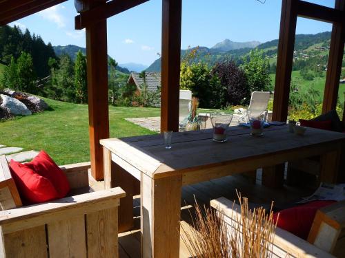 a table on a porch with a view of the mountains at Sunny Chalet in Les Gets with Jacuzzi in Les Gets