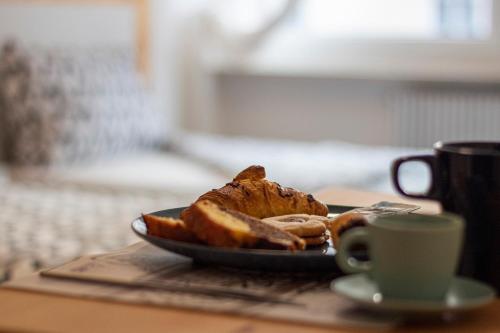 une assiette de pain et une tasse de café sur une table dans l'établissement Capri B&B, à Bolzano