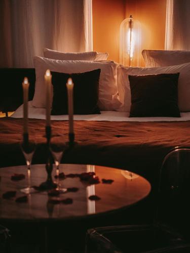 - une chambre avec un lit et une table avec deux bougies dans l'établissement Maison Marie-Astrid, Suite avec Balnéo privée, à Bordeaux
