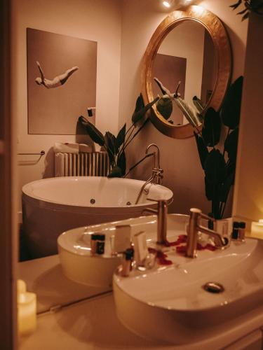 a bathroom with a sink and a tub and a mirror at Maison Marie-Astrid, Guest house , Suite avec Balnéo privée in Bordeaux