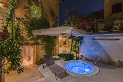 einen Whirlpool auf einer Terrasse mit Sonnenschirm in der Unterkunft Corte Alma Spa and Luxury Home in Gargnano